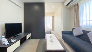 A modern living room with a flat-screen TV, a sofa, a coffee table, and a large window with curtains. - Pangoo Shinagawa (Tokyo)