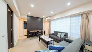 A modern living room with a sofa, coffee table, and dining area.