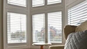 A room with a large window, a round orange table, and a beige armchair with a quilted pillow. - Rockcliffe Boutique 2-bed Apartment in Whitby (Whitby)