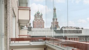 A balcony with a wicker chair and a view of a building with multiple domes. - 1BR Apt and Balcony next to Railway Station (Tampere)