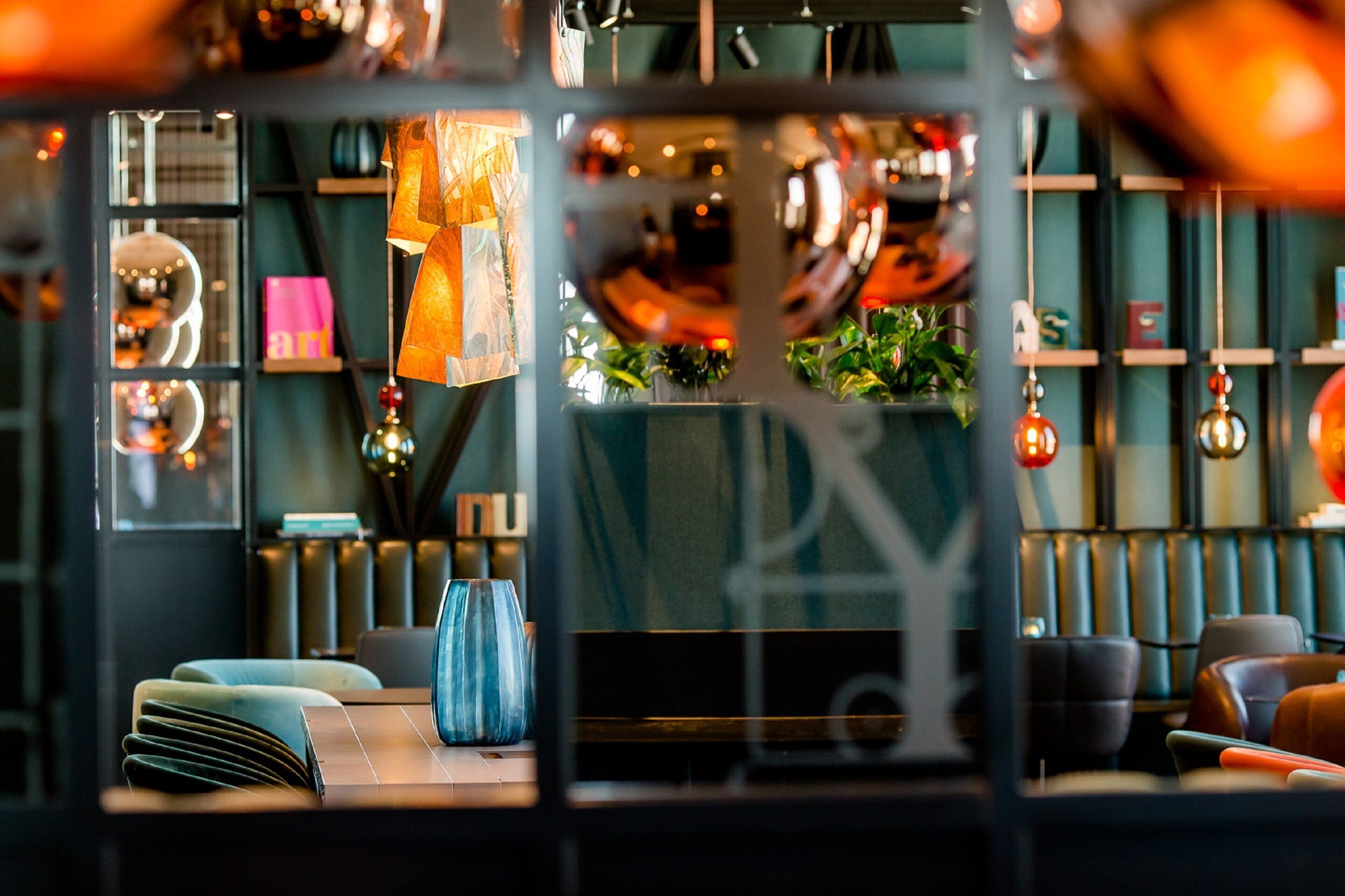 Un interior moderno con una zona de estar, iluminación decorativa y vistas a través de una ventana.