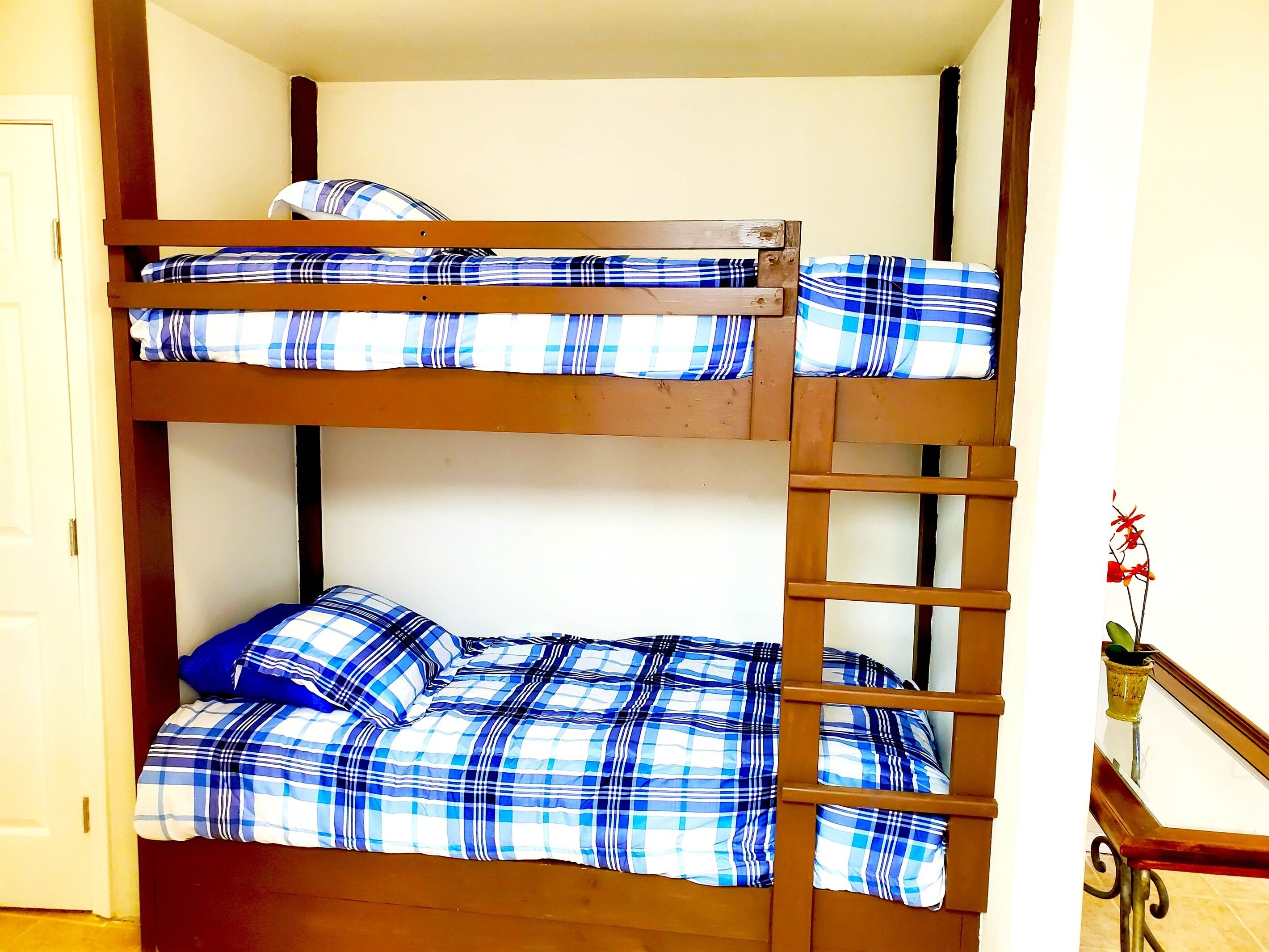A bunk bed with blue and white checkered bedding.