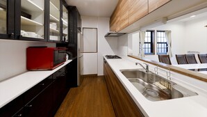 A compact kitchen with a microwave, sink, and cabinets.