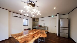 Una cocina amplia con una gran mesa de madera, electrodomésticos modernos y una lámpara de techo original.