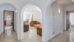 Amplia sala de estar con sofá, mesa de centro y arcos que conducen a otras habitaciones.
