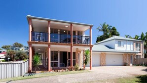 A two-story house with a balcony, a garage, and a well-maintained lawn. - Redman Views Unit 1  13 Redman Place (Soldiers Point)