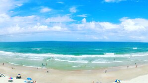 Une plage avec un ciel dégagé et une mer calme.