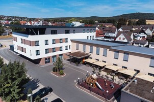 A hotel with a modern design, featuring a rooftop playground and outdoor seating area.