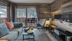 Ein modernes Wohnzimmer mit einer Couch, einem Couchtisch und einem Fernseher.