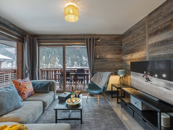 A modern living room with a sofa, coffee table, and TV. - 6-person flat - modern, close to the centre and slopes, terrace (CHATEL)