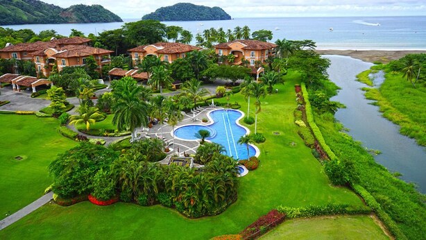 Un resort con varias edificaciones, una piscina y un río.