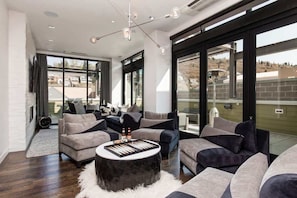 A modern living room with a large window, a round coffee table, and a sofa set.