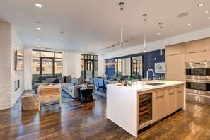 A modern kitchen with a central island, stainless steel appliances, and a dining area with a view. - Abode at Parkite #24, hot tub, balcony overlooking Main Street, gym, luxury condo (Park City)