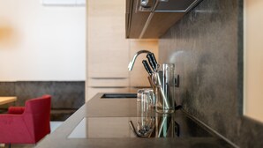 A modern kitchen with a stainless steel faucet, a glass container, and a knife block. - Sport Apart (Zell am Ziller)