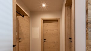A narrow hallway with wooden flooring and doors, leading to a room. - Sport Apart (Zell am Ziller)
