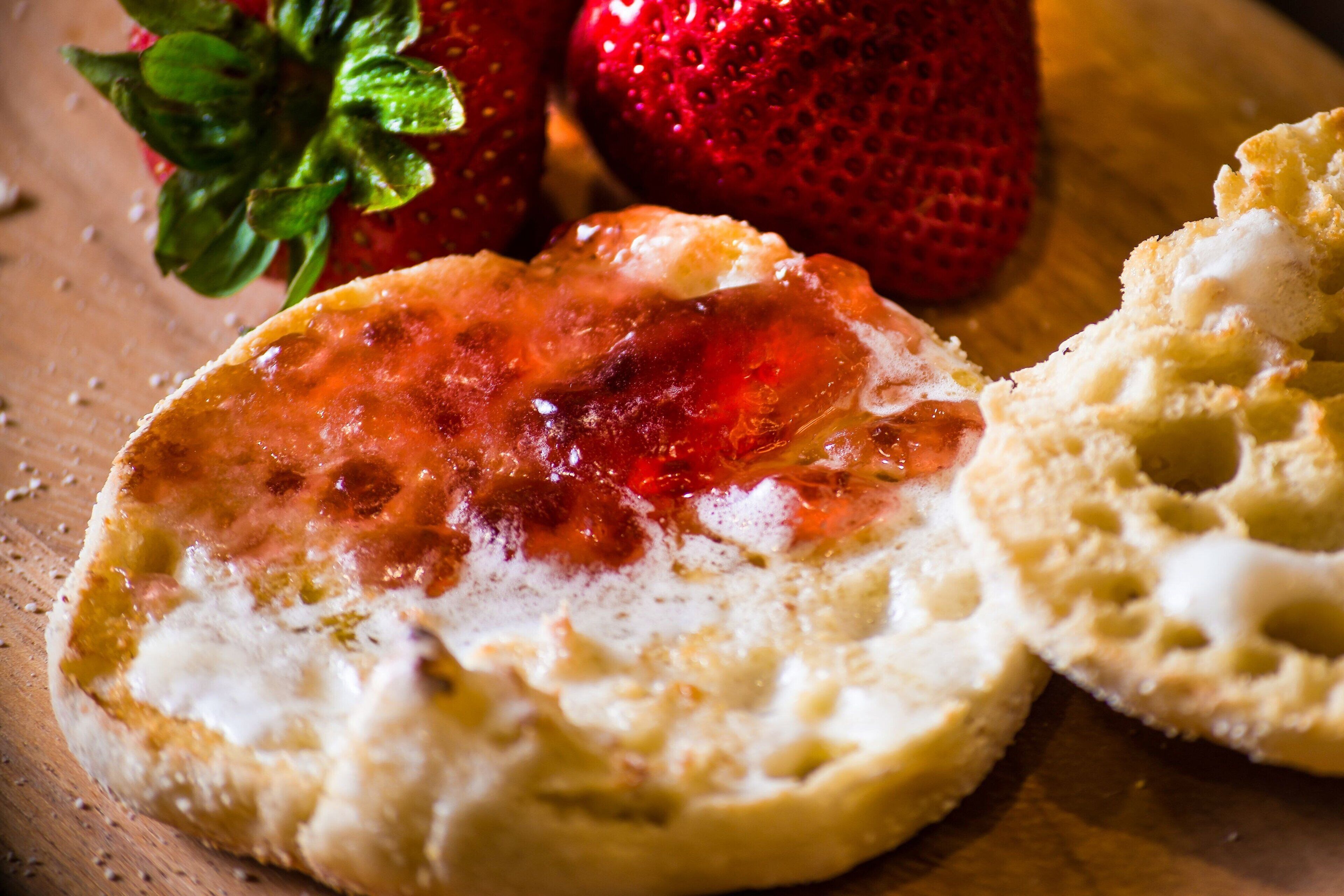 Eine Scheibe Toast mit Marmelade und einer Erdbeere.