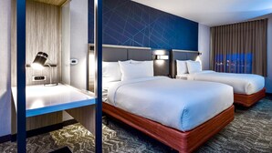 A hotel room with two beds, a desk, a lamp, and a view of the city at night. - SpringHill Suites by Marriott Kenosha (Kenosha)