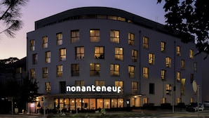 A hotel with a modern facade, multiple windows, and a visible entrance. - Nonanteneuf Aigle (Aigle)