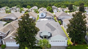 A residential area with houses featuring sloped roofs and front yards with trees. - Immaculate 4 Bedrooms 3 Bathroom In Windsor Palms Villa by RedAwning (Kissimmee)