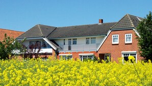 A two-story house with a red brick facade, a grey roof, and a balcony. - Kuschelige Butze an der Ostsee (Heringsdorf)