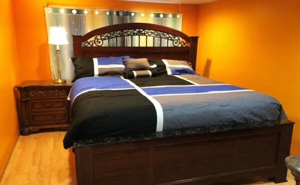 Restful retreat with a dark bed frame, metalwork headboard, and plush bedding.
