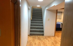 Staircase leads to a cozy bedroom with a bed.