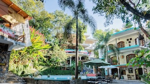 A courtyard with outdoor seating, a stone staircase, and lush greenery. - Hotel Paraiso Encantado (Xilitla)