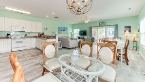 A spacious living area with a dining table, chairs, and a kitchen in the background. - An Amazing Surfside Beach Escape (Surfside Beach)