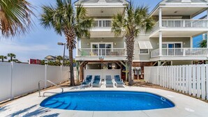 A two-story house with a swimming pool, a covered patio, and a fenced backyard. - An Amazing Surfside Beach Escape (Surfside Beach)
