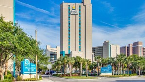 A tall hotel building with a prominent sign reading "Sand Dunes Resort." - Sand Dunes Resort by Escape (Myrtle Beach)