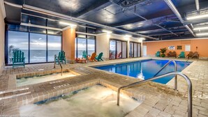 An indoor pool with clear views of the ocean, a sauna area, and several Adirondack chairs. - Sand Dunes Resort by Escape (Myrtle Beach)