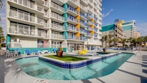 A hotel with a pool area, multiple balconies, and a clear blue sky. - Atlantica Resort 751 (Myrtle Beach)