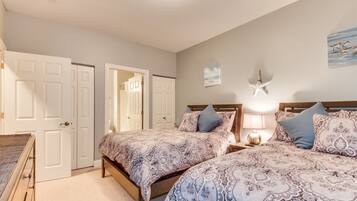 A bedroom with two beds, a nightstand, a lamp, and a starfish decoration on the wall.