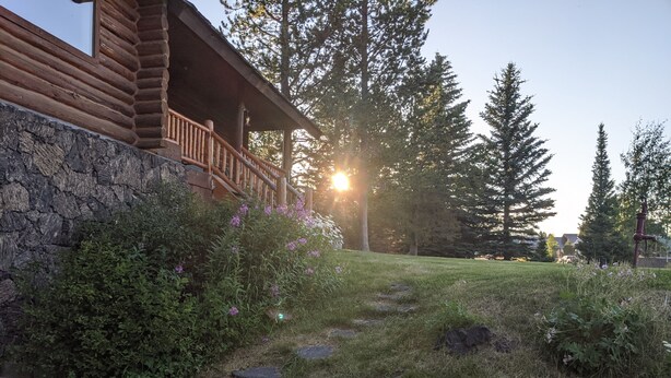 A log cabin with a stone foundation, a wooden deck, and a stone pathway leading to the entrance. - Sleeps 27, Dog Friendly, Fireplace, Ping Pong, Bumper Pool Table, Jetted tub (Fremont County)