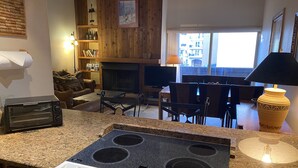 Eine Küche mit Herd, Toaster und einem Essbereich mit Stühlen und Tisch.