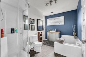 Un baño moderno con ducha, inodoro, lavabo y bañera.