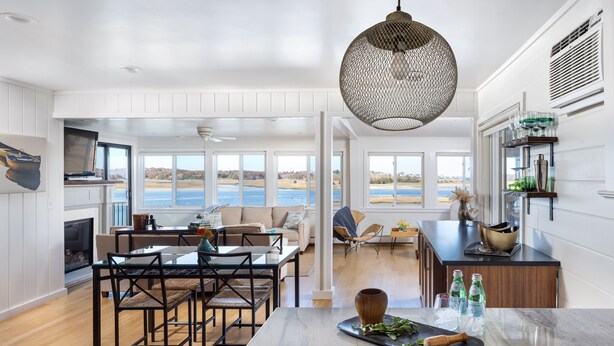 A spacious kitchen with a large island, a dining area, and a view of the ocean.