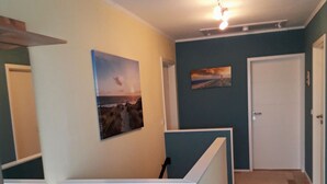 A room with a bed, a desk, and a door. - Vacation apartment Am Damm with a direct view of the Rhine DTV 4 stars (Wesel)