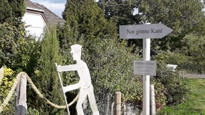 A sculpture of a man on a boat, a directional sign, and a plaque. - Vacation apartment Am Damm with a direct view of the Rhine DTV 4 stars (Wesel)