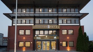A modern hotel with a flat roof, large windows, and a sign reading "LIVINGTON HOTEL". - Livington Hotel (Vallingby)
