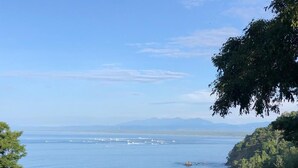 Un paysage côtier offrant une vue sur la mer et les montagnes lointaines.