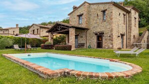 A stone building with a swimming pool, outdoor seating, and a garden. - San Rocco 4, Emma Villas (Montecchio)