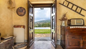 A rustic interior with an open door leading to a scenic view of a town and mountains. - San Rocco 4, Emma Villas (Montecchio)