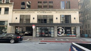 Un bâtiment portant une enseigne « Wanderer », un panneau indiquant une zone de chargement et une vitrine faisant la publicité de bureaux à louer.