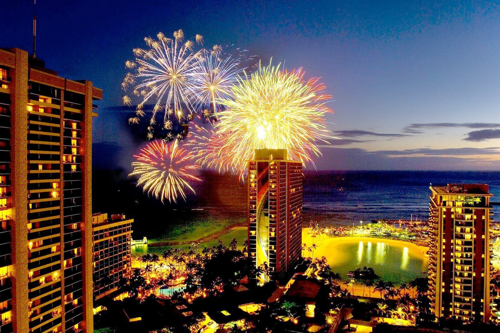 A hotel with multiple high-rise buildings, a beachfront, and a pool area.