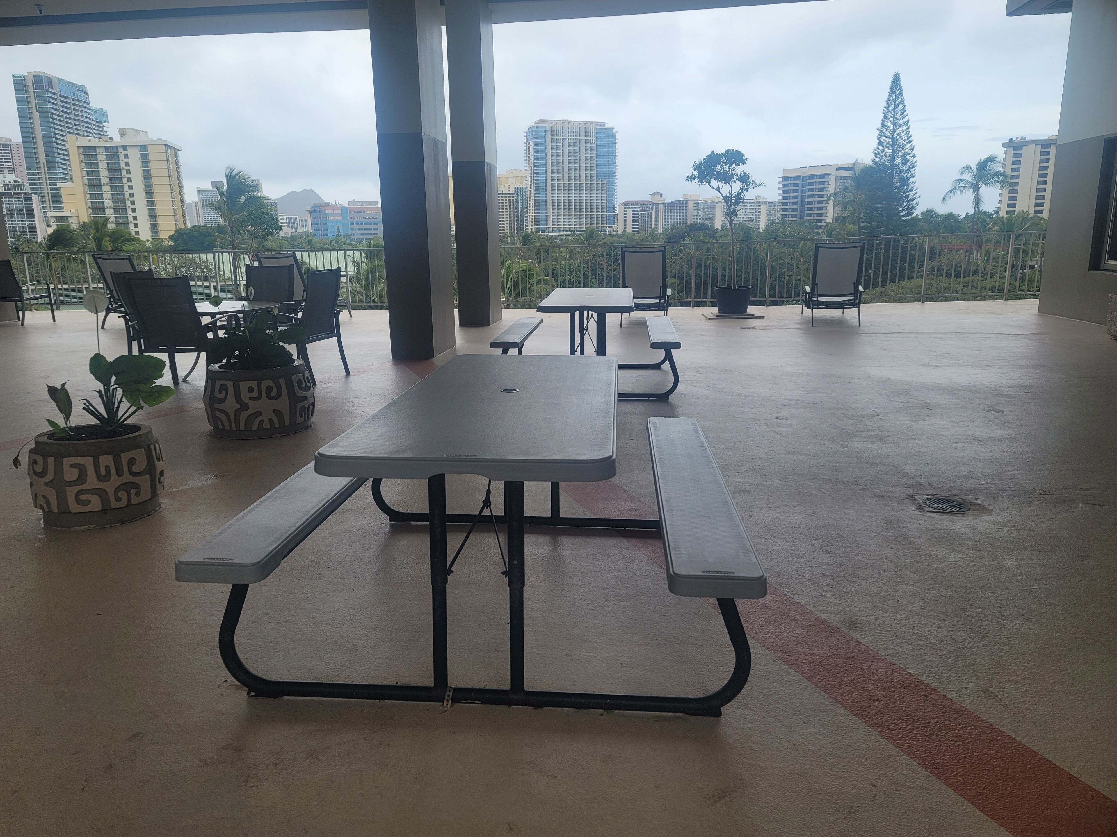An outdoor patio area with picnic tables and potted plants.