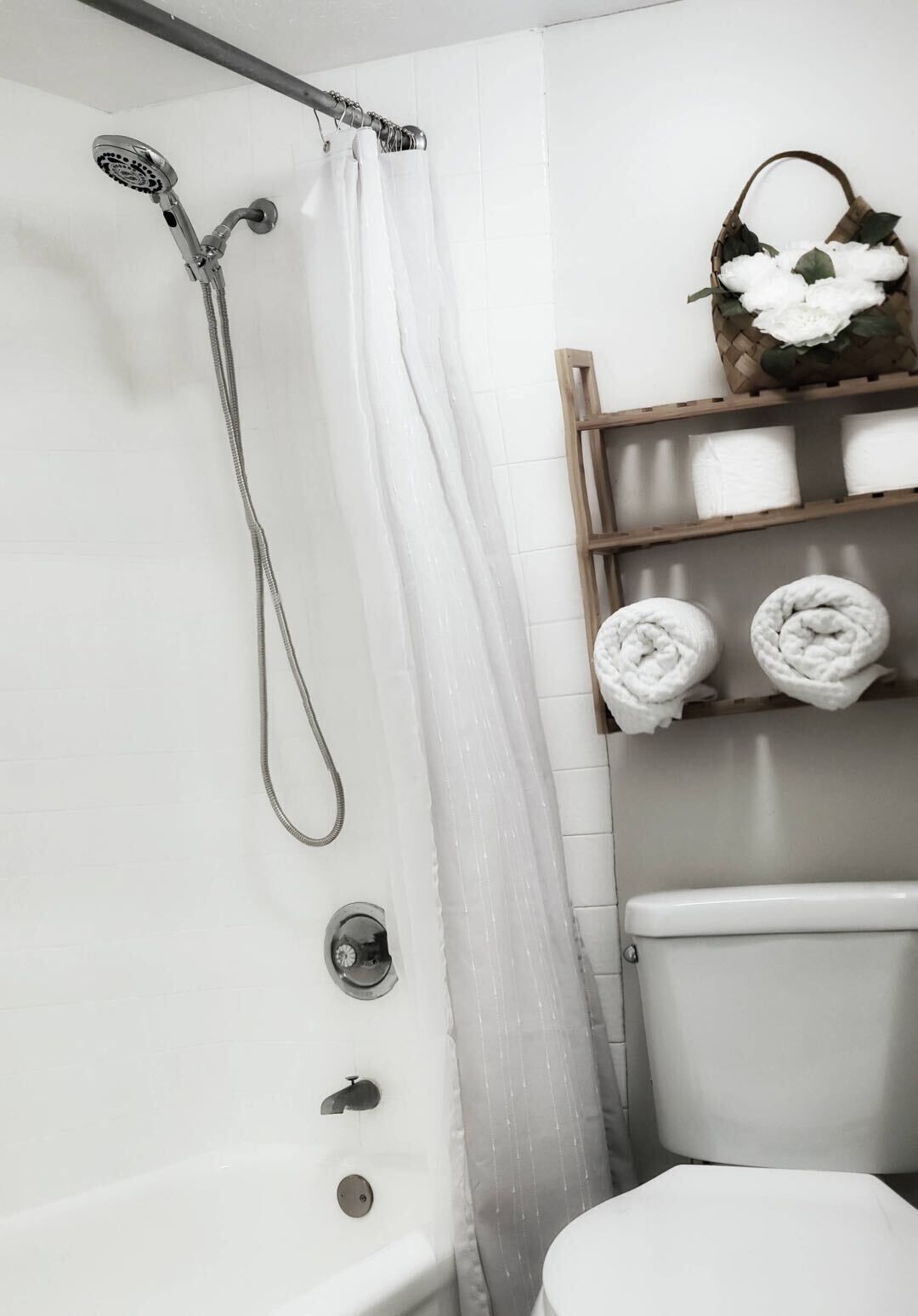 Un bagno con doccia, WC e scaffali con asciugamani.