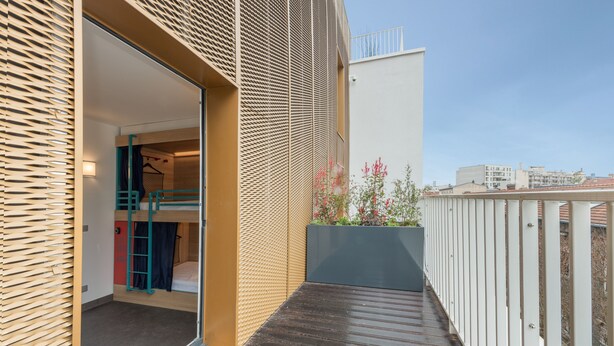 A modern apartment with a balcony, a wooden floor, and a view of the city. - Hostel HOSHO Paris Sud Porte d'Italie (Le Kremlin-Bicetre)