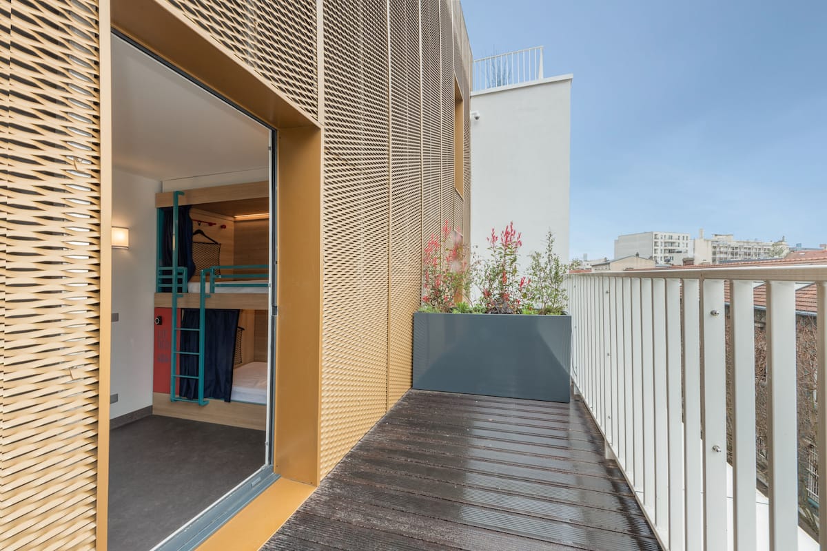 Eine moderne Wohnung mit Balkon, Holzboden und Blick auf die Stadt.