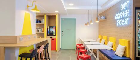 Un interior de cafetería moderna con mostrador, zona de asientos y un letrero de neón.